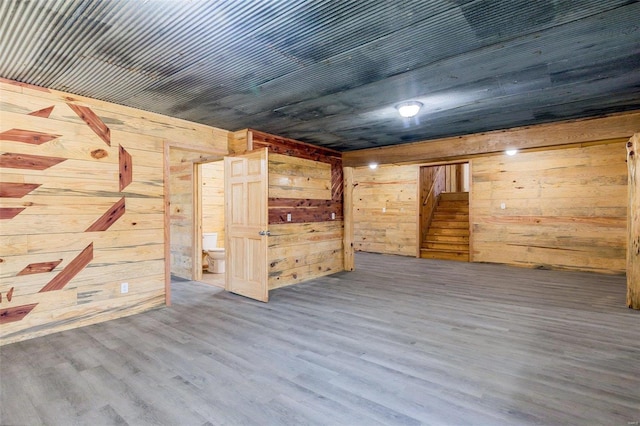 empty room with hardwood / wood-style flooring and wood walls