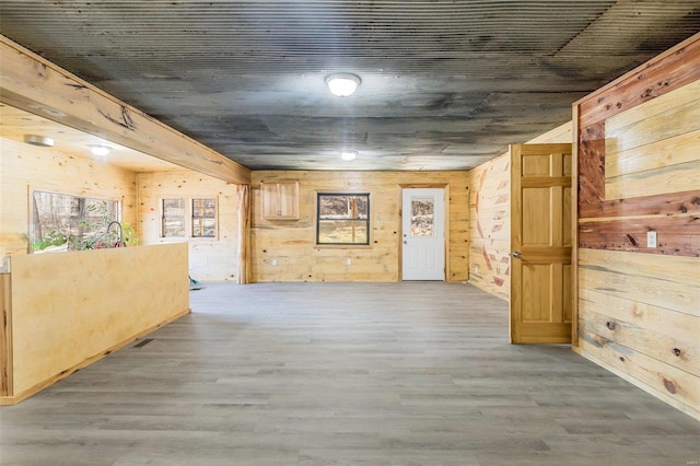 interior space with wood walls and light hardwood / wood-style flooring