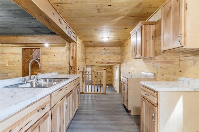 kitchen with light brown cabinets, sink, and wood walls