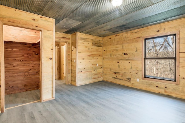 interior space with hardwood / wood-style floors and wood walls