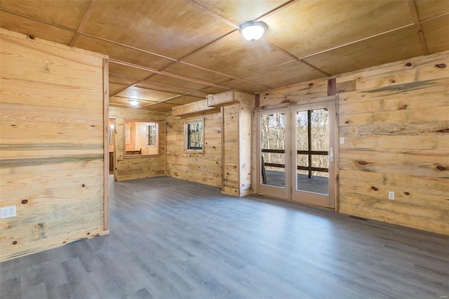 unfurnished room with hardwood / wood-style flooring and wooden walls