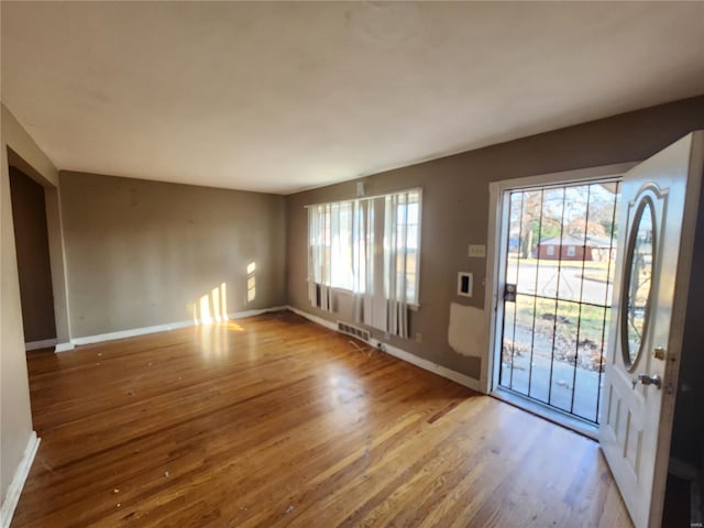 interior space with wood finished floors, visible vents, and baseboards