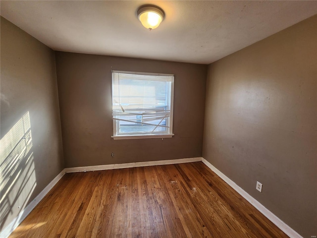 unfurnished room with wood finished floors and baseboards