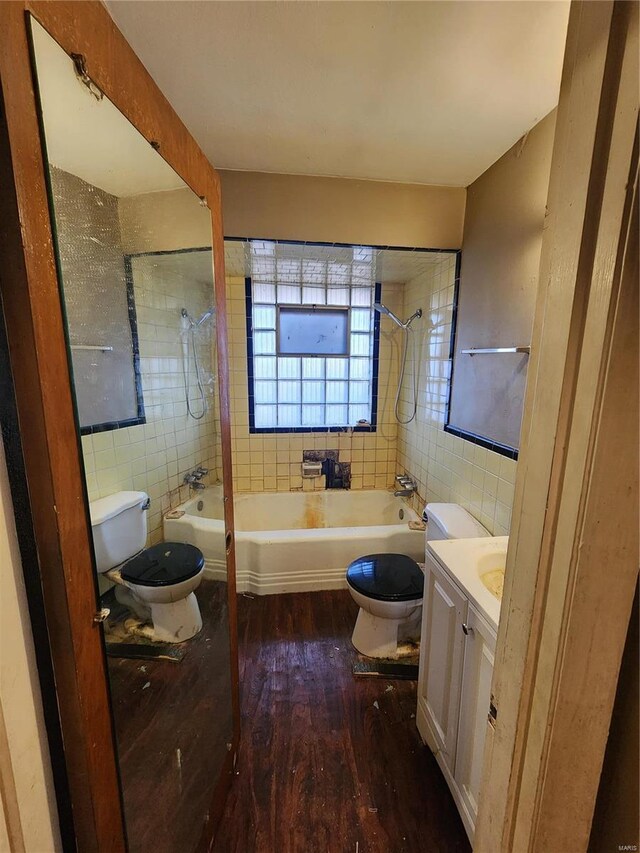 bathroom with vanity, wood finished floors, toilet, and tile walls