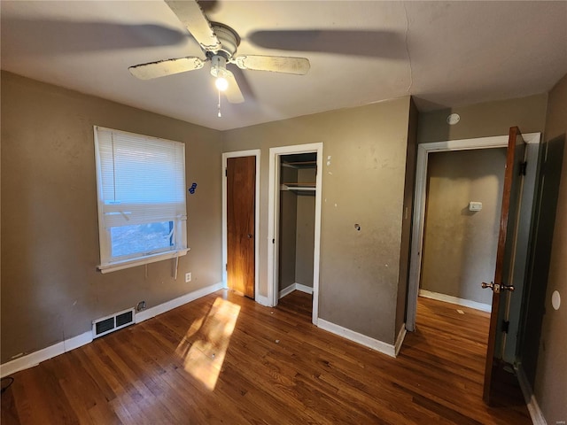 unfurnished bedroom featuring baseboards, visible vents, and dark wood-style flooring