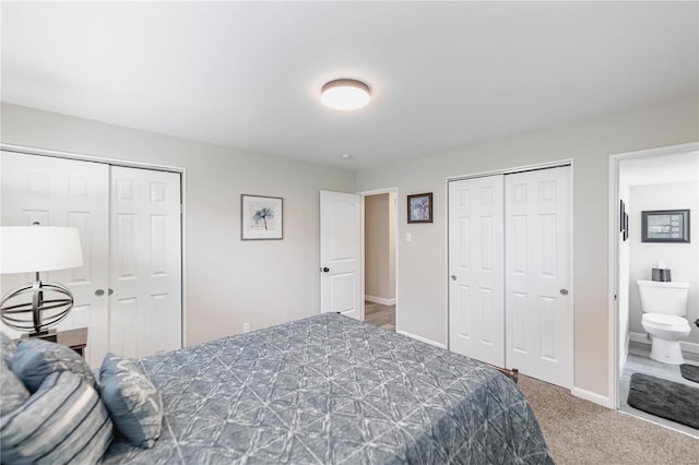 carpeted bedroom with connected bathroom and multiple closets