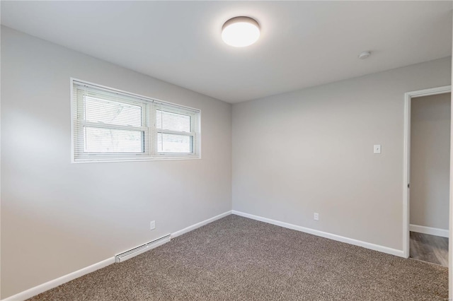 unfurnished room with carpet floors and a baseboard heating unit