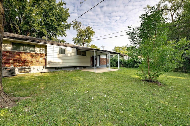 rear view of property featuring a yard and a patio