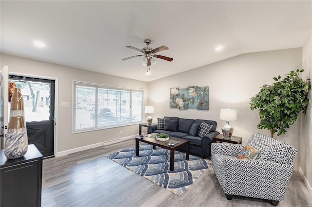 living room with ceiling fan, wood-type flooring, and vaulted ceiling