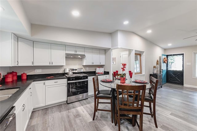 kitchen featuring vaulted ceiling, white cabinetry, appliances with stainless steel finishes, and light hardwood / wood-style flooring