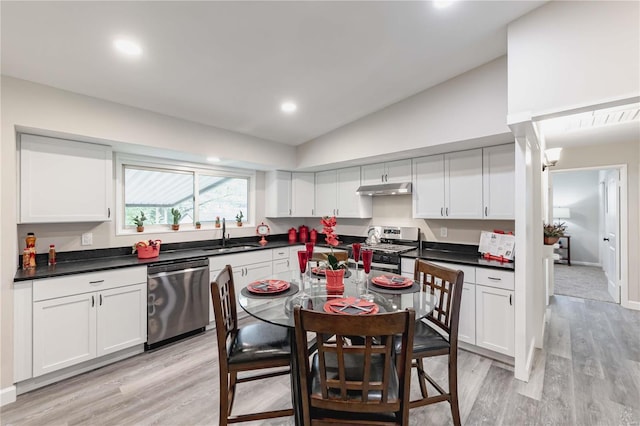 kitchen with white cabinets, stainless steel appliances, extractor fan, and vaulted ceiling