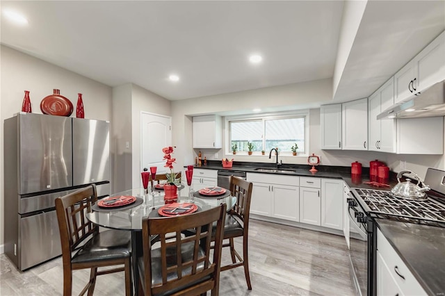 kitchen with white cabinets, light wood-type flooring, sink, and appliances with stainless steel finishes