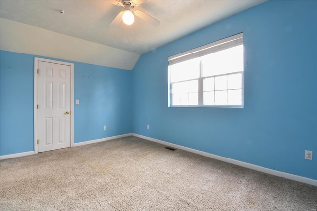 carpeted empty room featuring ceiling fan and vaulted ceiling