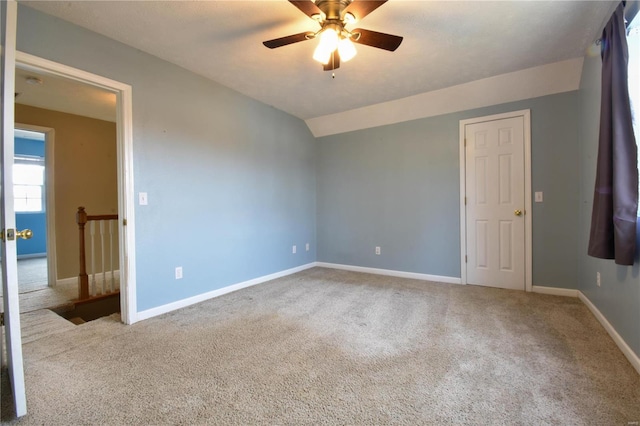 empty room featuring carpet, ceiling fan, and vaulted ceiling