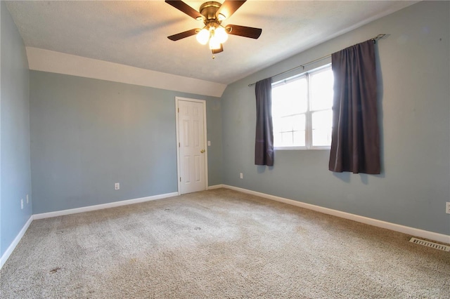 carpeted spare room with ceiling fan and lofted ceiling