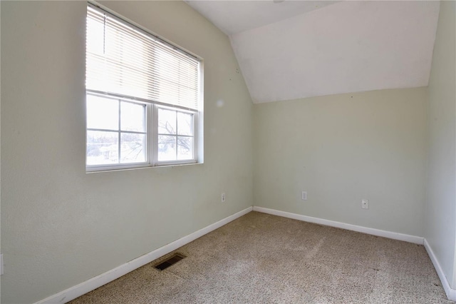 additional living space featuring a wealth of natural light, light colored carpet, and lofted ceiling