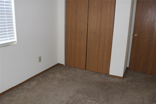 unfurnished bedroom with carpet flooring and a closet