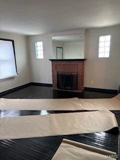 unfurnished living room with a brick fireplace and plenty of natural light