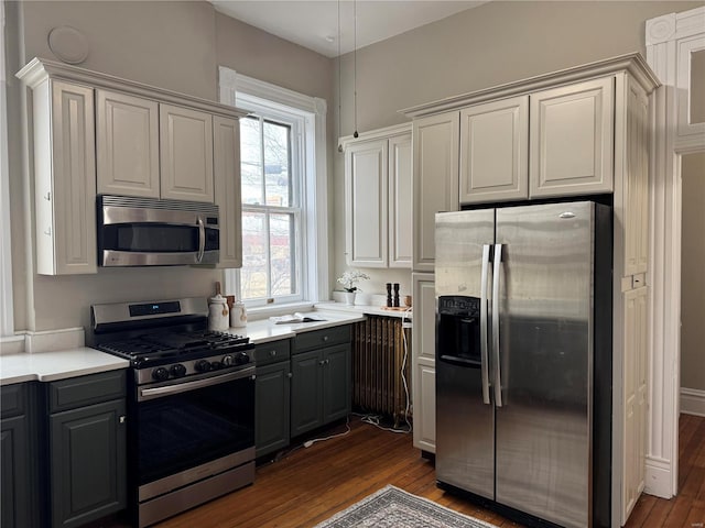 kitchen featuring gray cabinetry, white cabinetry, dark wood-type flooring, and appliances with stainless steel finishes