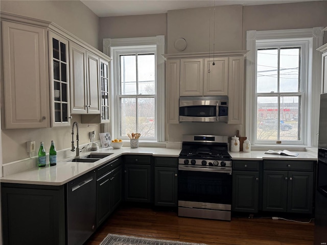 kitchen with stainless steel appliances, white cabinetry, and a healthy amount of sunlight