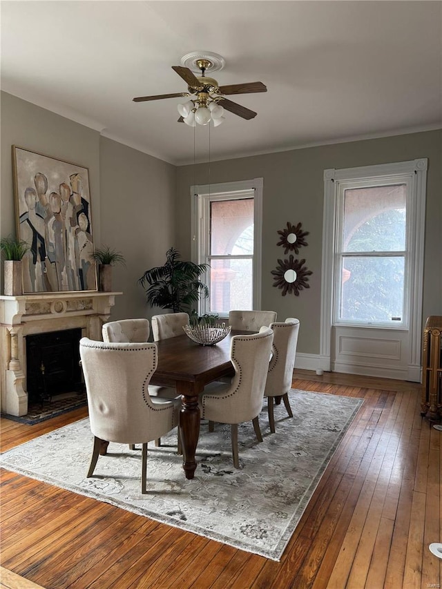 dining space with a wealth of natural light, hardwood / wood-style floors, ceiling fan, and crown molding