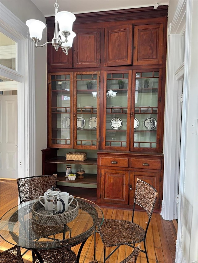 dining space with dark hardwood / wood-style floors and a chandelier