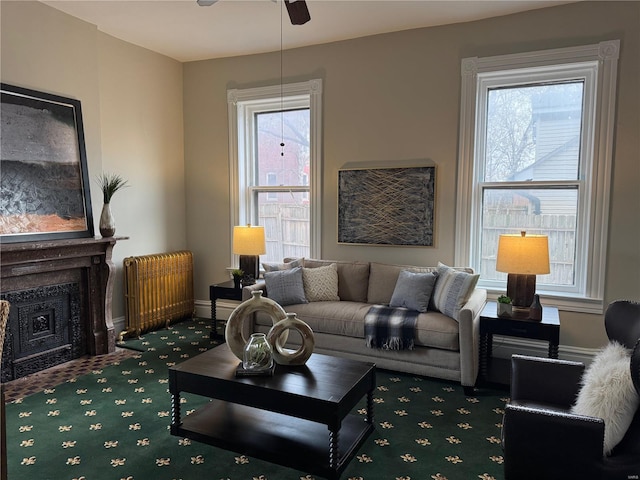 living room featuring carpet flooring, ceiling fan, and radiator