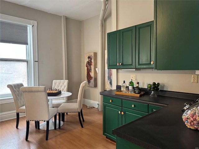 kitchen with light hardwood / wood-style floors, plenty of natural light, and green cabinets