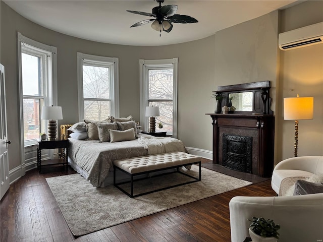 bedroom featuring dark hardwood / wood-style floors, a wall unit AC, and ceiling fan