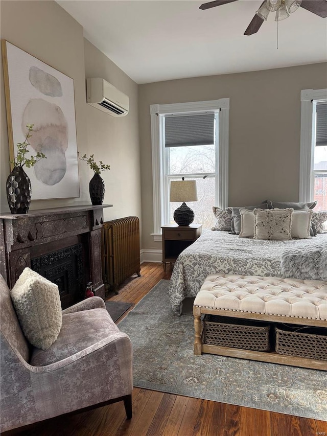 bedroom with a wall mounted air conditioner, hardwood / wood-style floors, and multiple windows