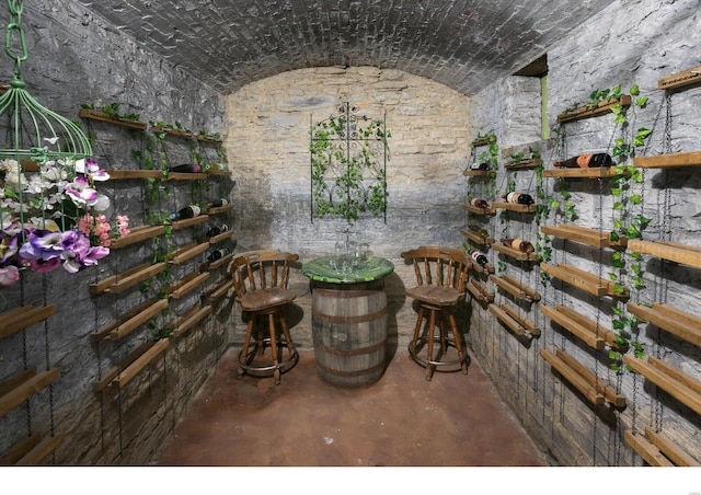 wine cellar with concrete flooring and vaulted ceiling