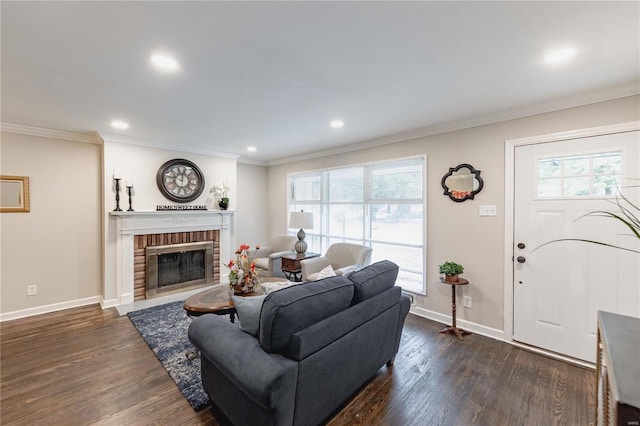 living room with crown molding, dark wood-type flooring, and a brick fireplace