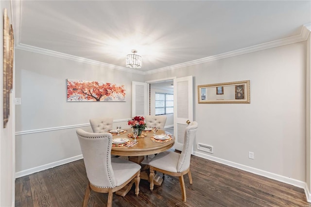 dining space with dark wood-type flooring, a notable chandelier, and ornamental molding