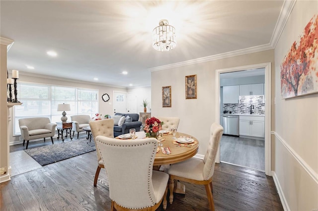 dining room featuring crown molding, sink, dark wood-type flooring, and a notable chandelier