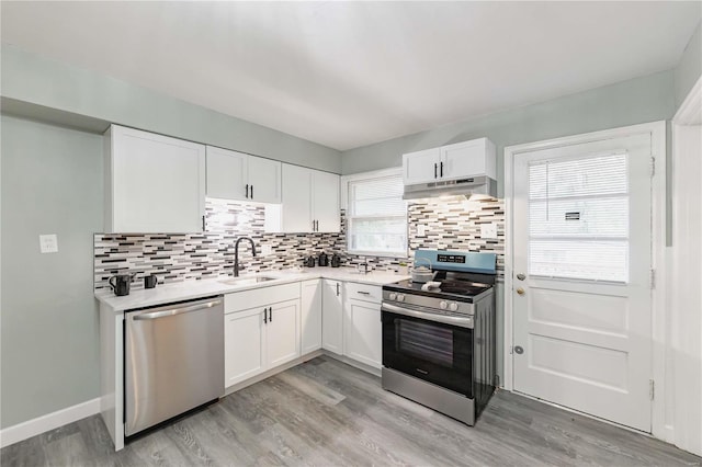 kitchen featuring stainless steel appliances, white cabinetry, plenty of natural light, and sink