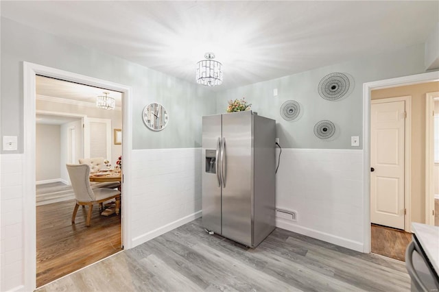 kitchen featuring stainless steel fridge, an inviting chandelier, and hardwood / wood-style flooring