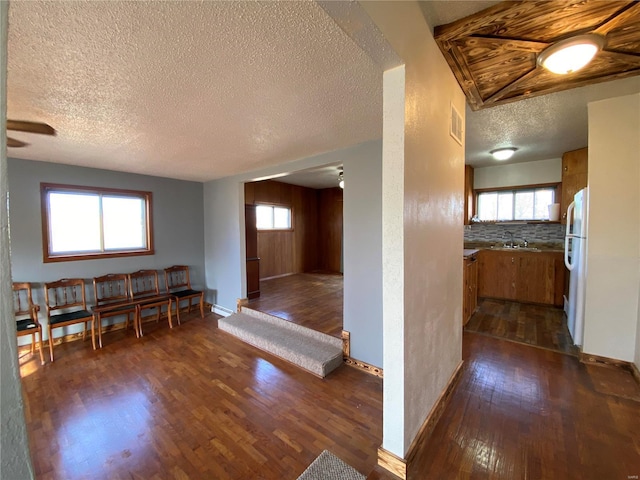 unfurnished dining area featuring dark hardwood / wood-style floors, sink, and a textured ceiling