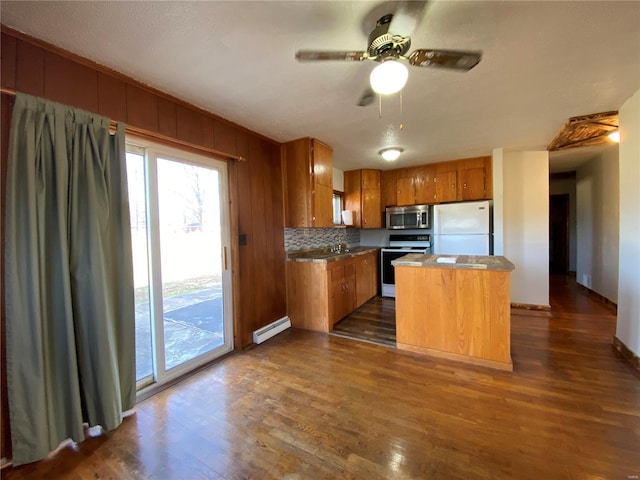 kitchen with a center island, a baseboard radiator, dark hardwood / wood-style flooring, white appliances, and decorative backsplash