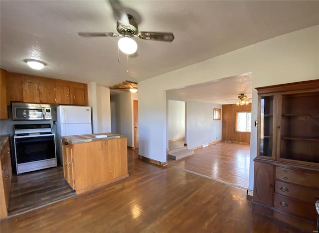 kitchen featuring white appliances, dark hardwood / wood-style floors, ceiling fan, a textured ceiling, and a kitchen island