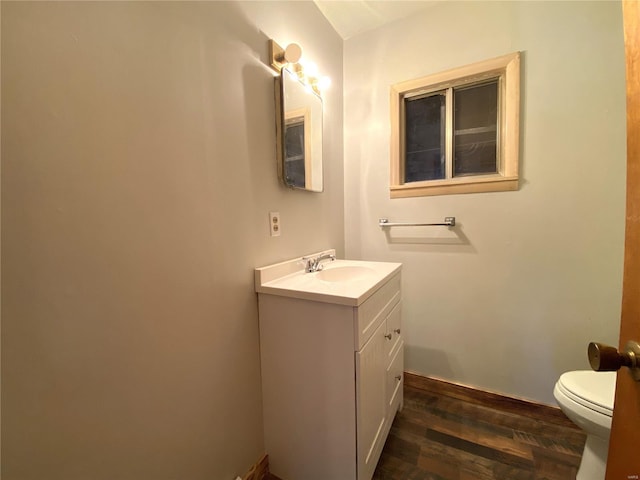 bathroom featuring vanity, wood-type flooring, and toilet