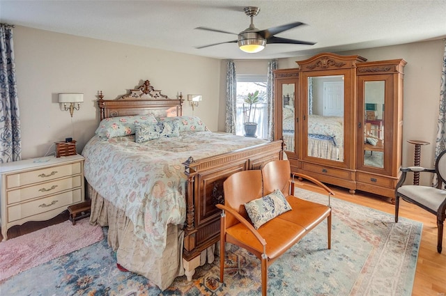 bedroom with a textured ceiling, light hardwood / wood-style floors, and ceiling fan