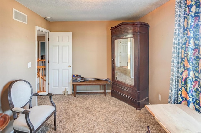 living area with light colored carpet and a textured ceiling