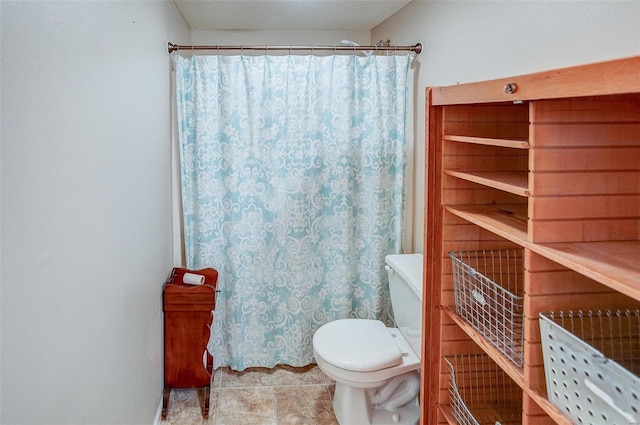 bathroom featuring tile patterned floors, a textured ceiling, and toilet