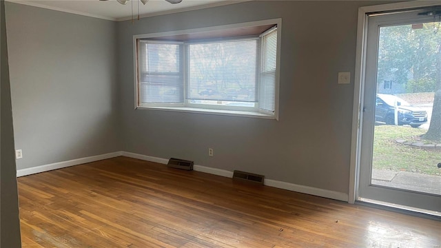 unfurnished room with ceiling fan, wood-type flooring, and ornamental molding