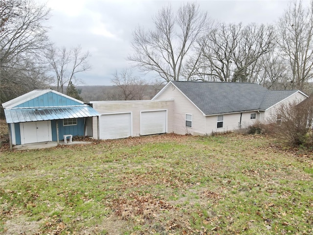 exterior space featuring a garage, a porch, and a lawn