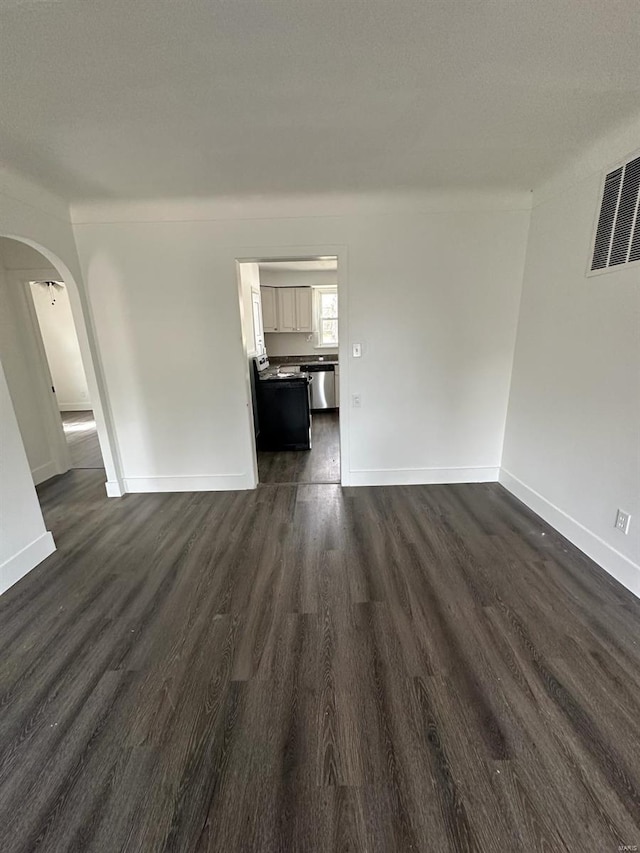 unfurnished living room featuring dark hardwood / wood-style flooring and a textured ceiling