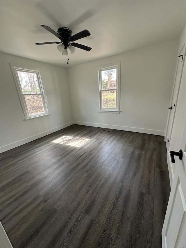 unfurnished room with dark hardwood / wood-style floors, plenty of natural light, and ceiling fan