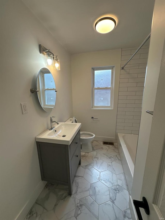 full bathroom featuring vanity, tiled shower / bath combo, and toilet