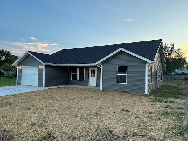 ranch-style home featuring a lawn and a garage