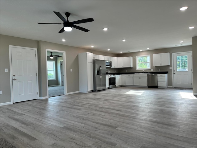 kitchen with light hardwood / wood-style floors, white cabinetry, and stainless steel appliances